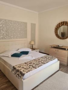 a bedroom with a large white bed and a mirror at Casa Dadi in Constanţa