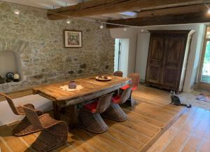 ein Esszimmer mit einem Holztisch und Stühlen in der Unterkunft Bordeneuve Chalet de Gaïa in Sonnac-sur-lʼHers