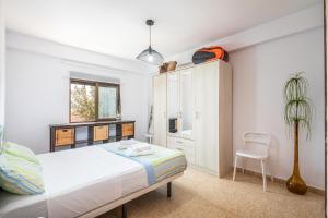 バレンシアにあるIsola Beachside Apartmentのベッドと椅子のある白い寝室 +41枚の写真