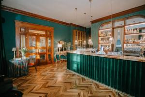 un bar in una stanza con pareti verdi e pavimenti in legno di Il Paese Boutique Hotel 
