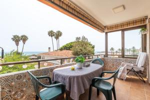 バレンシアにあるIsola Beachside Apartmentのテーブルと椅子と海のあるバルコニー