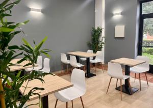 a room with tables and white chairs and plants at Hotel Alda Malvasía in Haro