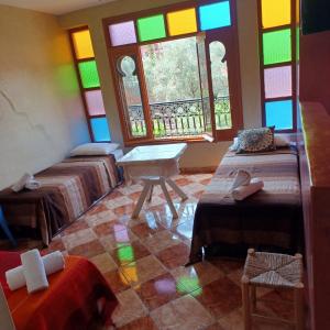Cette chambre comprend 3 lits et des vitraux. dans l'établissement Maison d´hôtes Amazir, à Ouzoud