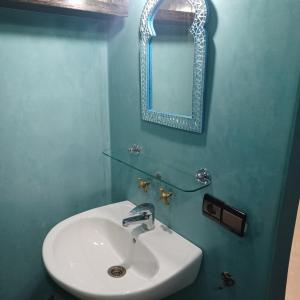 y baño con lavabo blanco y espejo. en Maison d´hôtes Amazir en Ouzoud