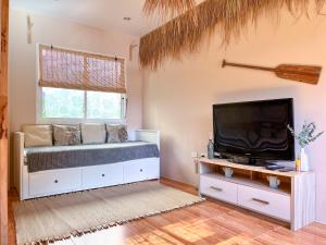a living room with a bed and a tv at Panwa beachfront apartments in Ban Ao Makham