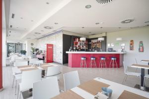 a restaurant with white tables and chairs and a counter at Ele Route 42 in Illescas