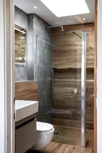 a bathroom with a toilet and a glass shower at Kingsley Lake View & Paddocks - A group retreat with hot tub, sports bars & spectacular lake views in the Mendip Hills AONB in Chew Stoke +73 photos