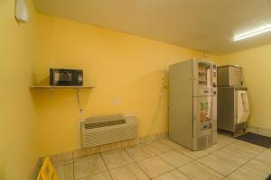 eine Küche mit einem Kühlschrank und einer Mikrowelle in der Unterkunft Day's Inn by Wyndham in Wichita Falls