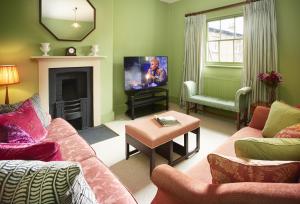 a living room with a couch and a tv at The Victorian Wing in Shifnal