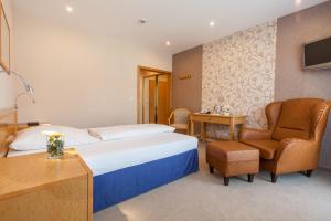 ベーヴェルンゲンにあるLandhotel Weserblickのベッドと椅子のあるホテルの部屋