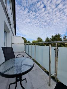 un patio avec une table en verre et une chaise sur un balcon dans l'établissement Apartament nr 209 Pastela w Welle, à Grzybowo