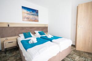- une chambre avec 2 lits dotés d'oreillers bleus et blancs dans l'établissement Apartament nr 209 Pastela w Welle, à Grzybowo