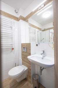 une salle de bain blanche avec un lavabo et des toilettes dans l'établissement Apartament nr 209 Pastela w Welle, à Grzybowo 11 autres photos