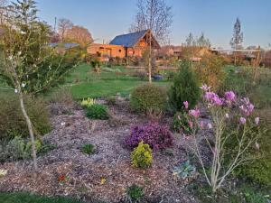 un jardín con flores y una casa de fondo en L’Ombragée Au Doux Refuge, en Courtonne-la-Meurdrac