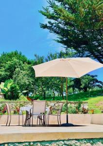 a table and chairs with an umbrella on a patio at Finca El Miruéndano in La Franca