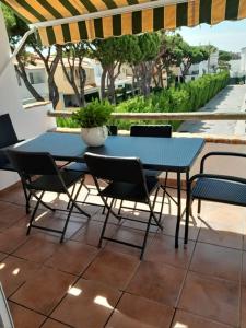 een blauwe tafel en stoelen op een patio bij APARTAMENTO PRIMERA LINEA DE PLAYA, LA BARROSA in Chiclana de la Frontera