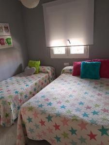 een slaapkamer met twee bedden met sterren erop bij APARTAMENTO PRIMERA LINEA DE PLAYA, LA BARROSA in Chiclana de la Frontera