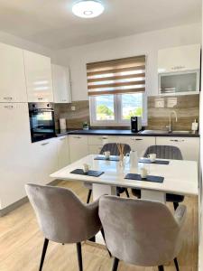 uma cozinha com uma mesa branca e 2 cadeiras em Villa Oliva Korcula em Korčula
