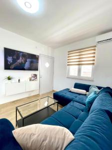 uma sala de estar com um sofá azul e uma televisão em Villa Oliva Korcula em Korčula