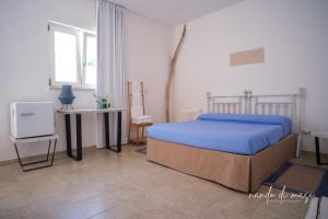 ポリニャーノ・ア・マーレにあるRooms Masseria Giangrandeのベッドルーム1室(ベッド1台、テーブル、椅子付)
