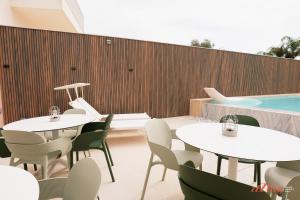 a restaurant with tables and chairs and a swimming pool at Spinola Stays in St. Julianʼs