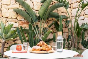 a table with a plate of croissants and a bottle at Spinola Stays in St. Julianʼs