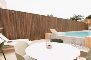 a pool with a table and chairs and a laptop on it at Spinola Stays in St. Julianʼs