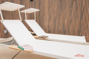 two white bunk beds in a room with a wooden wall at Spinola Stays in St. Julianʼs