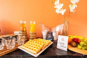 a table with a plate of waffles and fruit and drinks at Spinola Stays in St. Julianʼs