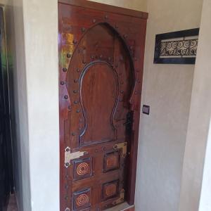 a wooden door in the corner of a room at Maison d´hôtes Amazir in Ouzoud