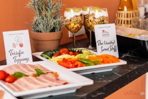 two plates of food on a table with vegetables and meat at Spinola Stays in St. Julianʼs