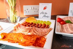 a plate of food on a table with meats and vegetables at Spinola Stays in St. Julianʼs