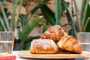 three pastries on a wooden plate on a table at Spinola Stays in St. Julianʼs