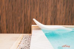 a white chair sitting next to a swimming pool at Spinola Stays in St. Julianʼs