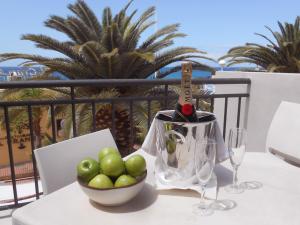 een tafel met een fles wijn en een fruitschaal bij Los Olivos Beach Resort in Adeje