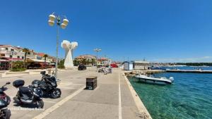 a group of motorcycles parked on a sidewalk next to the water at Refresh Boutique Suites - Central Point in Vodice