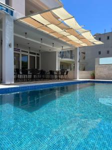 a large swimming pool with a patio with tables and chairs at Apartments Fat e Jet in Ulcinj