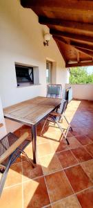 Une table et des chaises en bois sont disponibles sur la terrasse. dans l'établissement Nadija Rooms Funtana, à Funtana