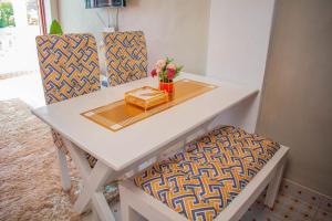 a white table with two chairs and a box on it at Emap Homes-serenity hse in Kilifi