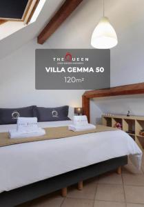a bed in a room with a sign that reads the queen villa gerama at The Queen Luxury Apartments - Villa Gemma in Luxembourg