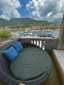 a rattan bed on a balcony with a view of a harbor at Villa Nela in Tivat