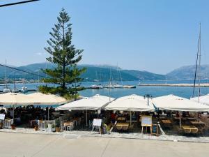 a restaurant with tables and umbrellas next to the water at Theseus Seafront House in Sami