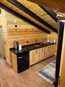 een keuken met een zwart aanrecht en houten wanden bij Hayvore Loft in Çamlıhemşin