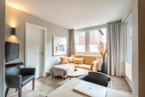 ein Wohnzimmer mit einem Sofa und einem Tisch in der Unterkunft Hotel Tide42 in Borkum