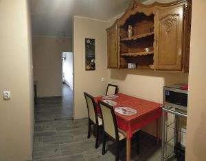 uma pequena cozinha com uma mesa vermelha e cadeiras em Lawendowy Dworek em Bałtów
