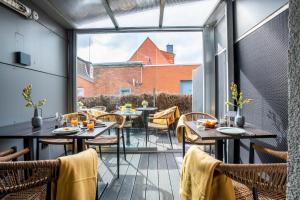 um restaurante com mesas e cadeiras e uma grande janela em Hotel Tide42 em Borkum