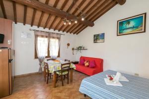 een woonkamer met een tafel en een rode bank bij Il Pino - monolocale Lavanda in Cecina