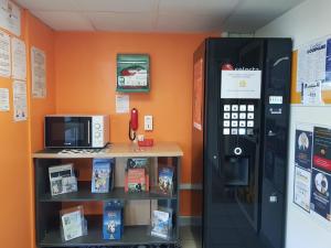 - un grand distributeur automatique à côté d'une étagère avec des livres dans l'établissement Première Classe Chateauroux - Saint Maur, à Saint-Maur