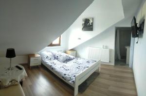 um quarto com uma cama branca e uma escada em Lawendowy Dworek em Bałtów