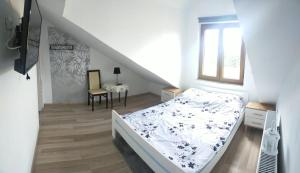 a white bedroom with a bed and a staircase at Lawendowy Dworek in Bałtów